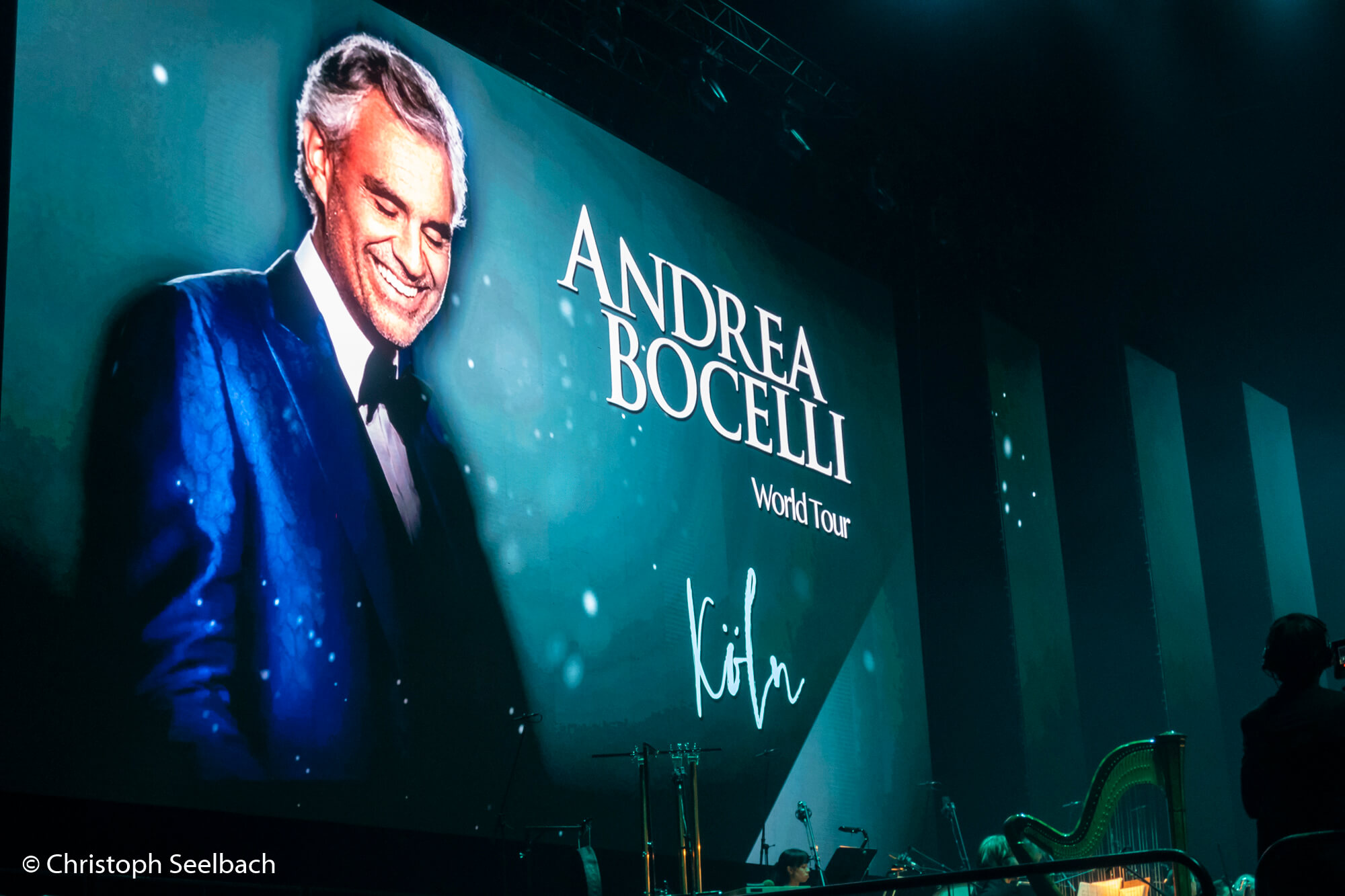 Beamer-Screen mit Foto von Andrea Bocelli und Titel “Andrea Bocelli World Tour”