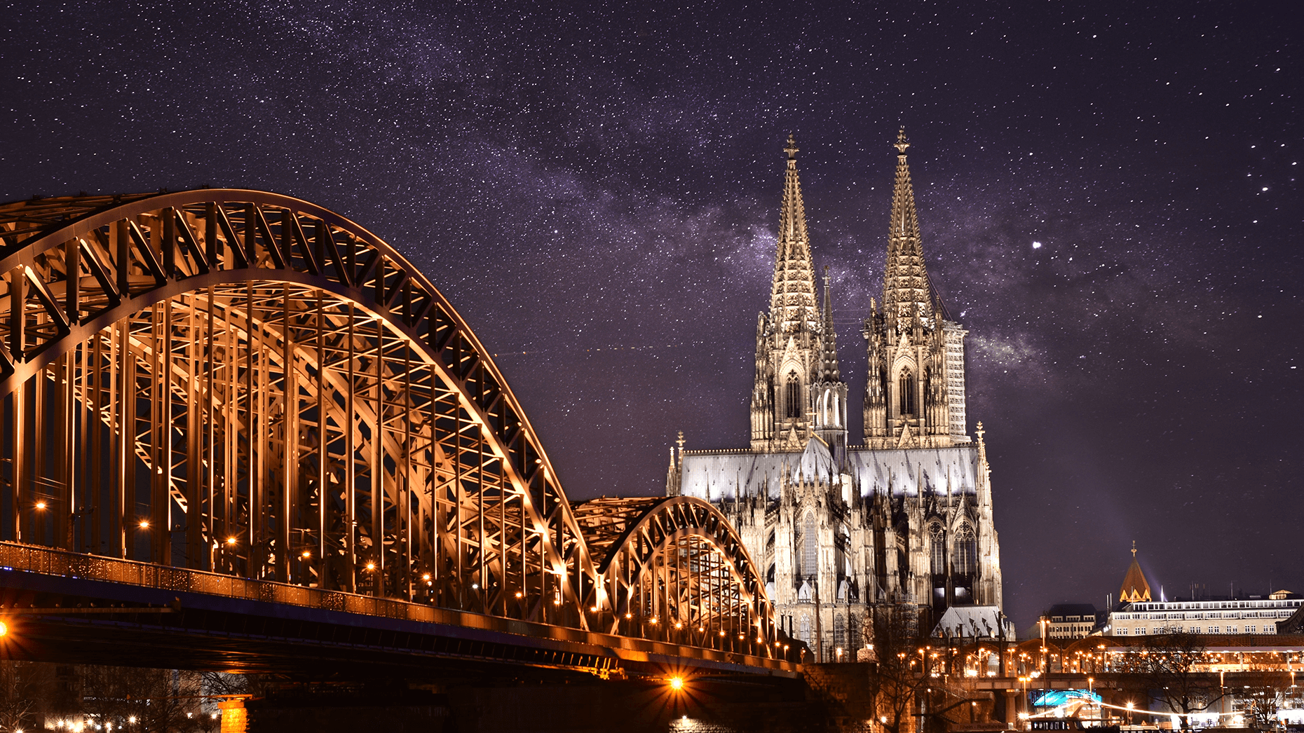 Kölner Dom und Hohenzollernbrücke angestrahlt vor Sternenhimmel