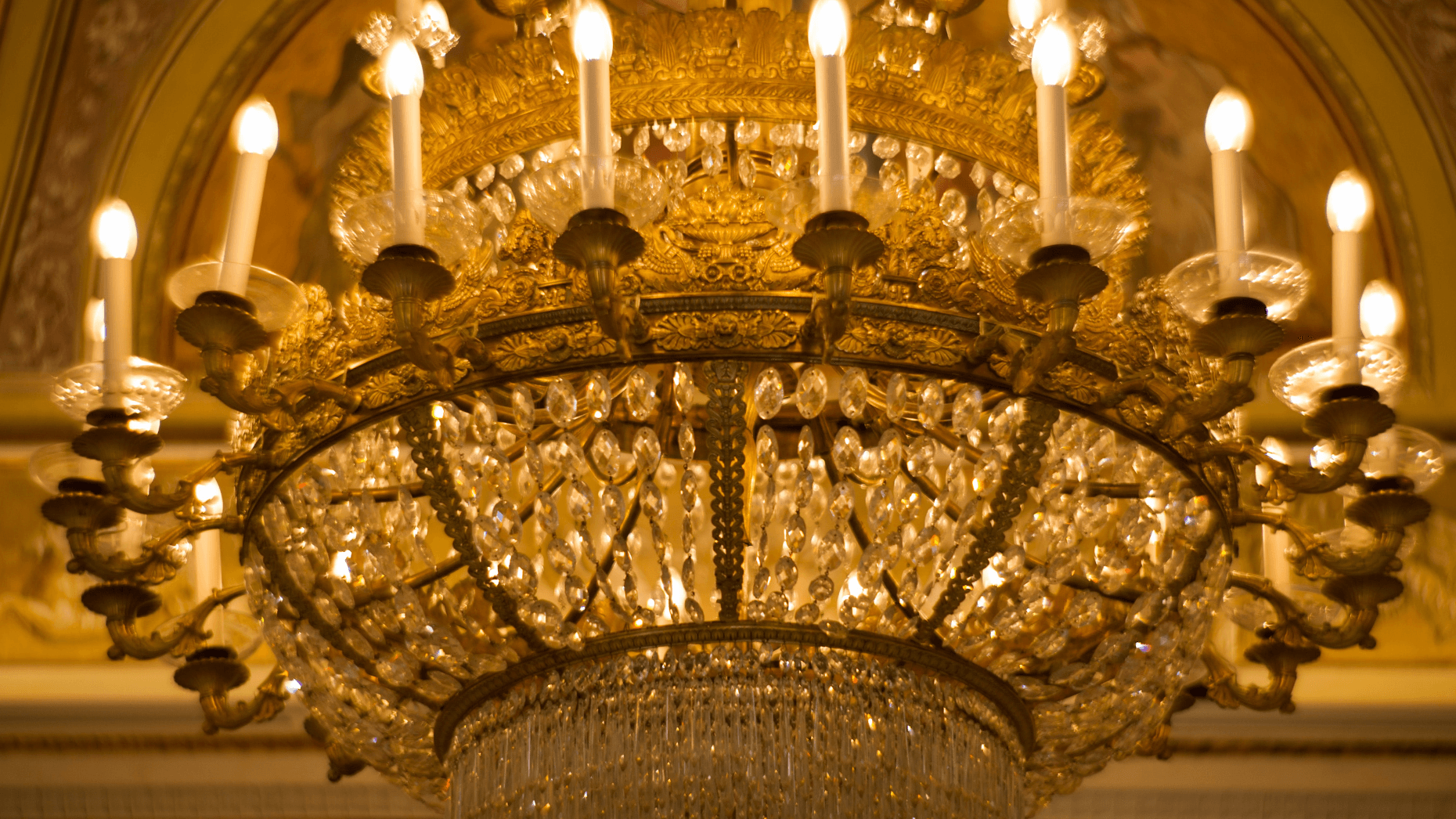 Prunkvoller goldener Kronleuchter in einem Opern-Treppenhaus